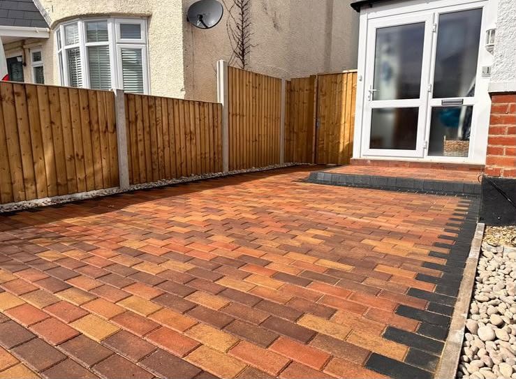 Brindle block paving laid in a small rear yard beside white French doors
