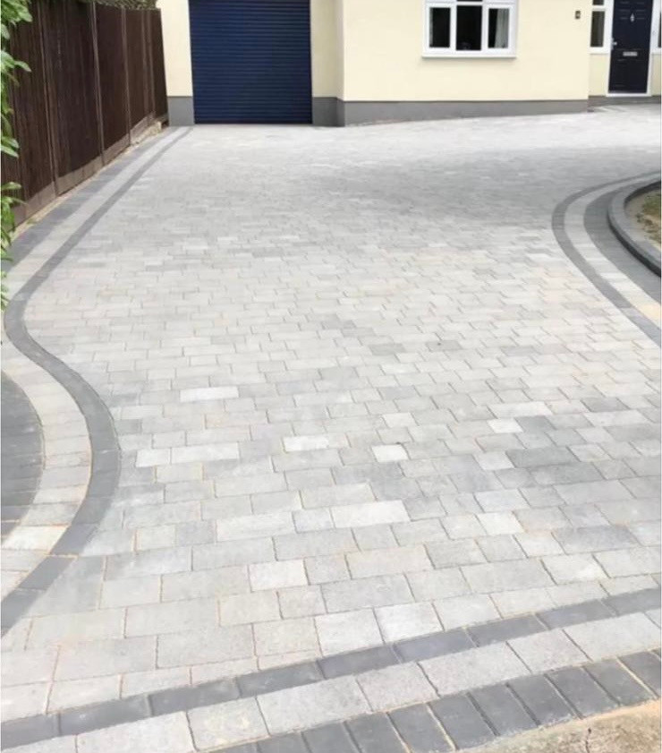 Block paved driveway with a curved border laid over a compacted sub-base