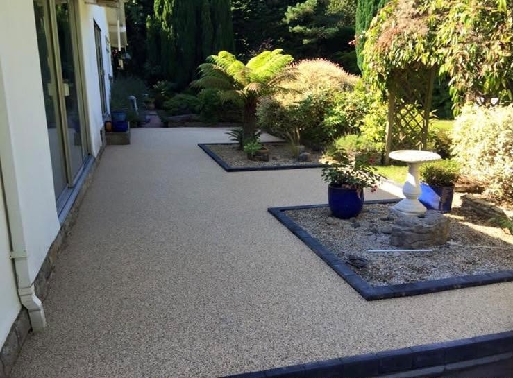 Resin bound driveway laid up to the house with planted beds and a level threshold at the doors