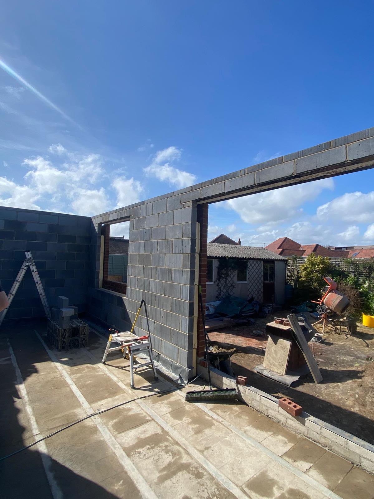 Single storey extension with blockwork walls up to plate height and a beam over a wide opening