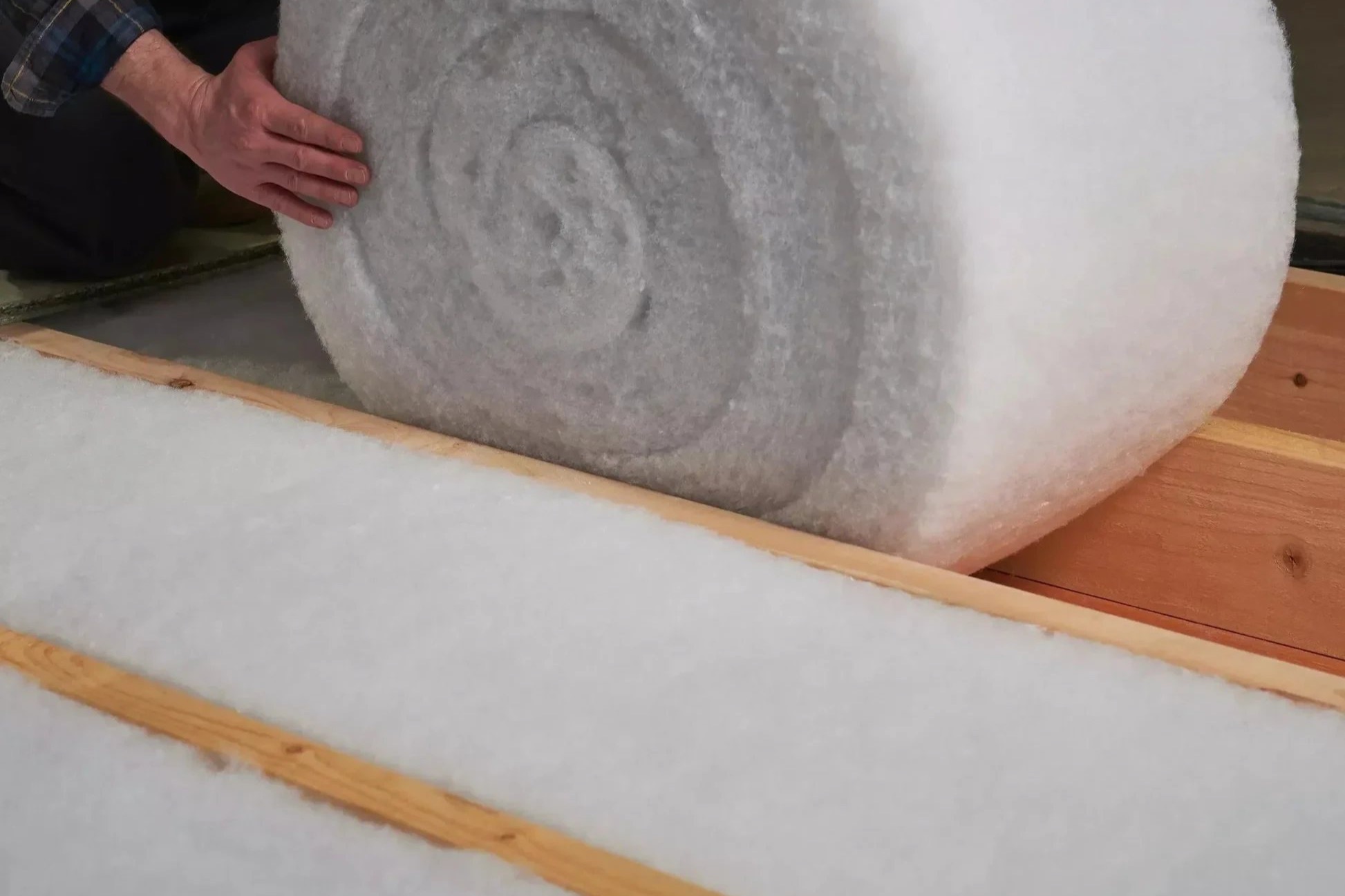 Mineral wool loft roll laid between and across the ceiling joists
