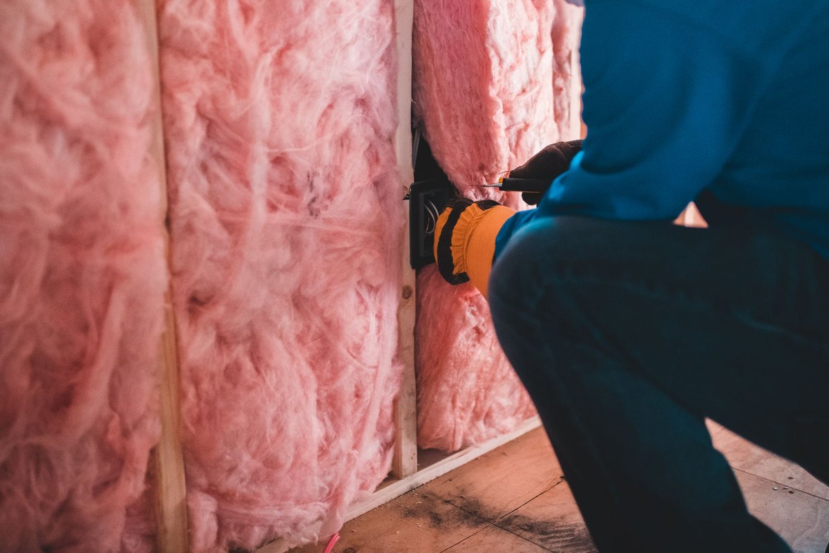 Mineral wool being fitted into the face of a wall between studs
