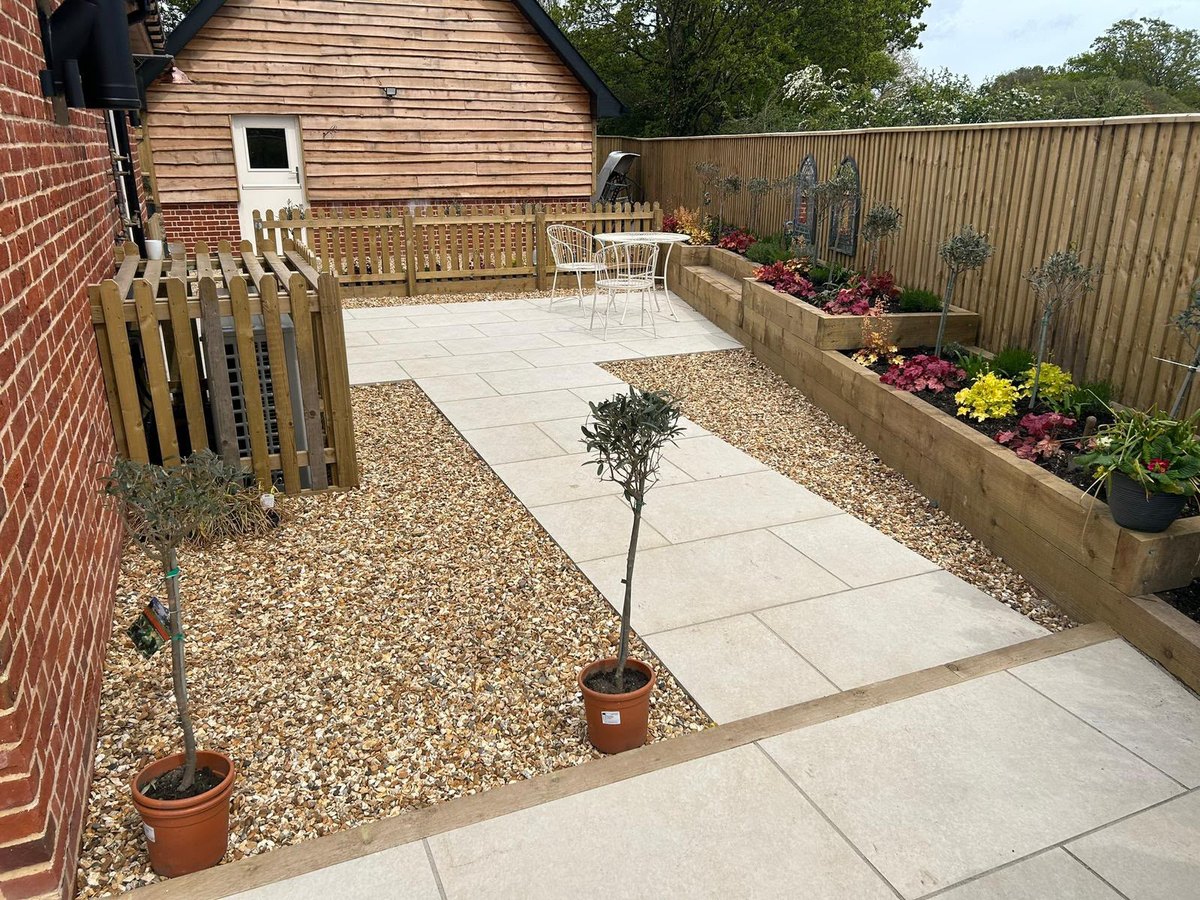Porcelain paving finished against a gravel margin at the base of a wall