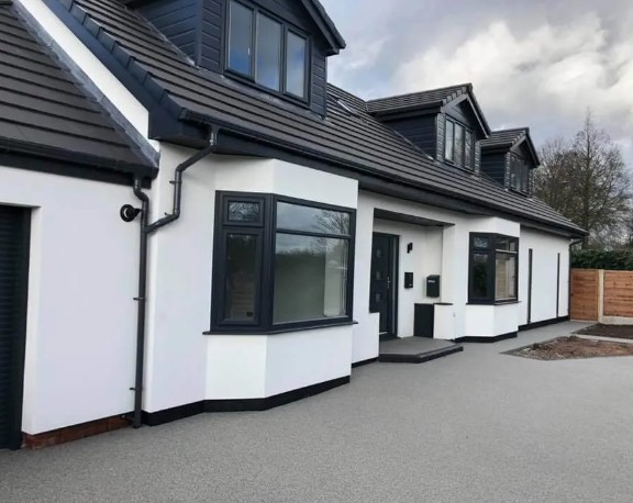 Finished bungalow in white render with a grey tiled roof and a resin driveway
