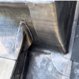 Lead flashing dressed and welted at a roof junction