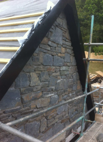 Stone-clad gable end on a house, with tight mortar joints between the stones